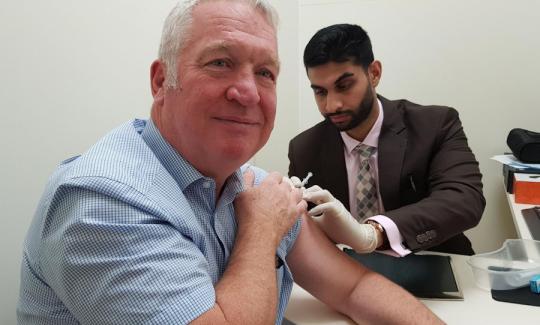 Sir Mike Penning gets his flu jab from pharmacist Jay Doshi at Woodhall Pharmacy